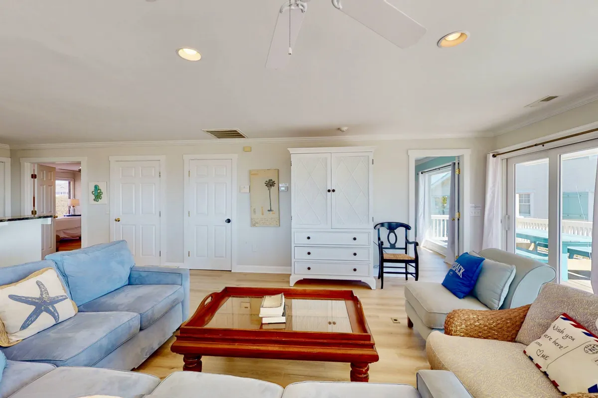 The photo depicts a welcoming living area with a blue sofa accented by starfish designs, a wooden coffee table, and a white cabinet. The cozy and relaxed atmosphere signals a comfortable space to regroup after a day of adventure.