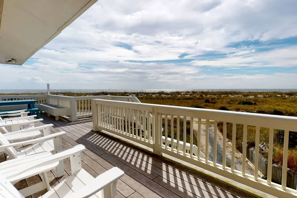 An exterior shot showcasing the home’s deck with Adirondack chairs, looking out over the ocean and sky. The inviting setup suggests tranquil mornings, evening gatherings, and uninterrupted sea views—all from the comfort of the property.